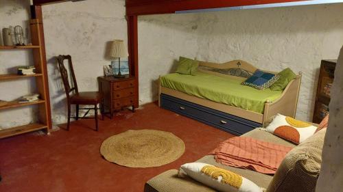 Un dormitorio con una cama, una silla y un sofá. en El Patio de Estrella, en Las Palmas de Gran Canaria