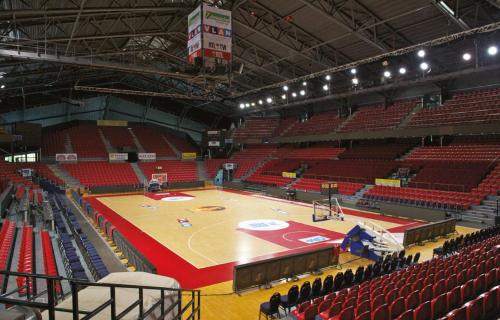 a basketball court in an arena with red seats at Ubuntu House - Charleroi in Charleroi
