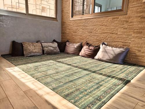 a couch sitting against a wall with pillows at Villa Maria - Appartement 2 in Saly Niakh-Niakhal