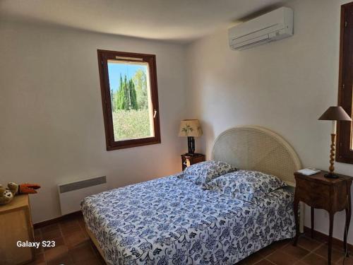 une chambre avec un lit avec une couette bleue et une fenêtre dans l'établissement Villa résidence piscine plage, à La Ciotat