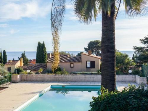 une piscine devant une maison avec un palmier dans l'établissement Villa résidence piscine plage, à La Ciotat