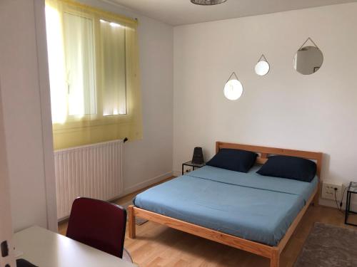 une chambre avec un lit avec des draps bleus et une fenêtre dans l'établissement appartement entier 2 chambres, à Beauvais
