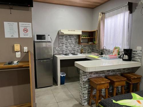 a kitchen with a sink and a stove top oven at Apartamentos Mansión Tropical in Quepos