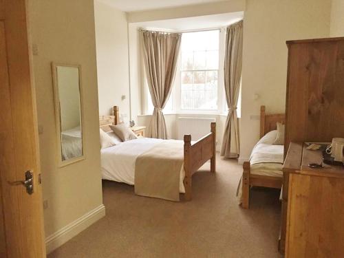 um quarto com 2 camas e uma janela em Three Crowns Guest House em Salisbury