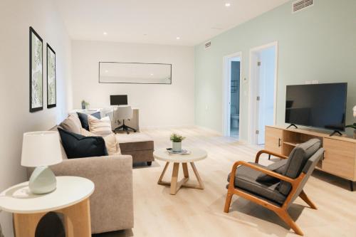 a living room with a couch and a tv at Governors Village - 1,2,3 & 4 Bedroom Apartments on Seven Mile Beach Corridor in George Town