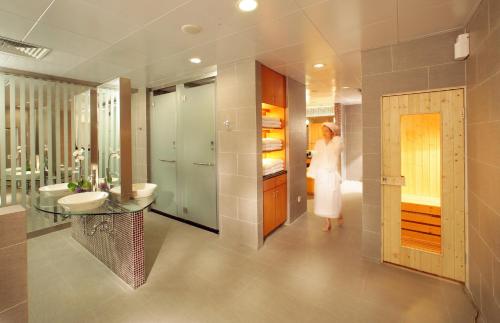 a woman in a bathroom with a sink and a mirror at Liuhua Hotel in Guangzhou