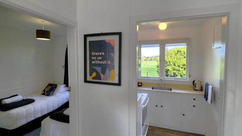 a white room with a bed and a window at U Studios Masterton in Masterton