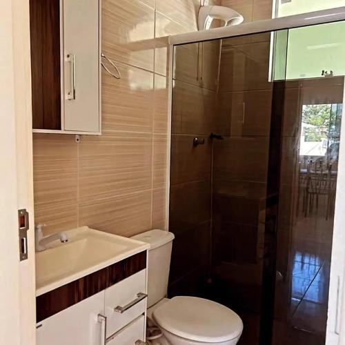 a bathroom with a toilet and a sink and a shower at Refugio da Camboa - Casa Laranja in Armação
