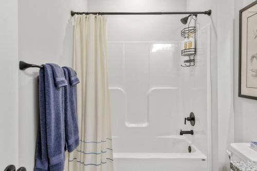 a bathroom with a shower with a blue towel at Fully-Fenced Backyard l Perfect for Families and Groups in Saint Peter