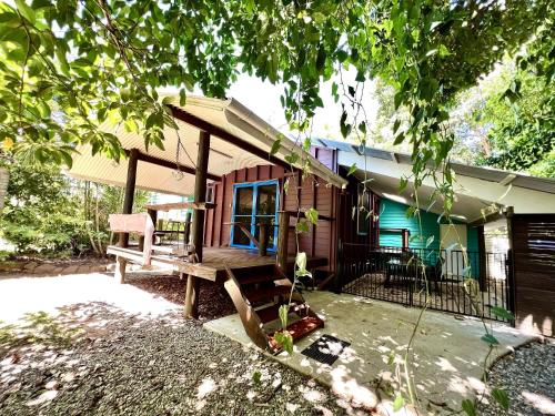 a house with a bench in front of it at Tropical Cabin Retreat in Mission Beach