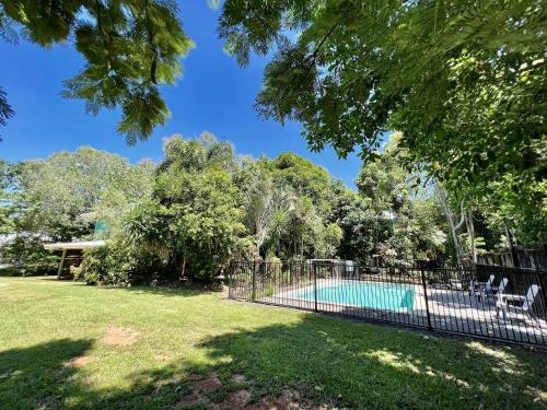 a fence around a swimming pool in a yard at Tropical Cabin Retreat in Mission Beach