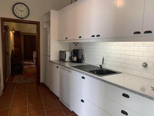 a kitchen with a sink and a clock on the wall at Quinta do Tojal - Tourism immersed in nature! in Vila Maior