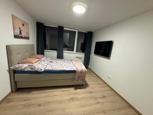 una camera da letto con un letto e una televisione di City Ferien Wohnungen 9 a Rosenheim