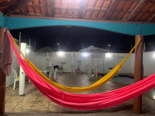 a red and yellow hammock in a room at Casa com piscina em Marudá in Maruda