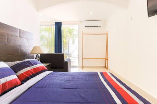 a bedroom with a large bed with a blue blanket at M&Z Loft Las Palmas in Cancún