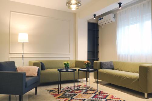 a living room with a couch and two tables at Studio Apartments in Novi Pazar