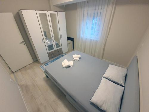 a bedroom with a bed with two towels and a mirror at Studio Apartments in Novi Pazar