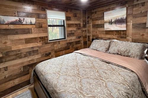 a bedroom with wooden accent walls and a bed at Great Little Cabin! in Ruidoso