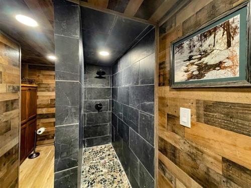 a walk in shower in a room with wood at Great Little Cabin! in Ruidoso