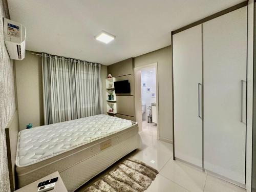 a bedroom with a bed and a walk in closet at Apartamento Luxuoso de 2 Dormitórios in Capão da Canoa