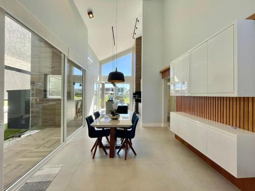 ein Esszimmer mit Tisch und Stühlen in der Unterkunft Casa Luxuosa no Condomínio Ilhas Resort in Capão da Canoa