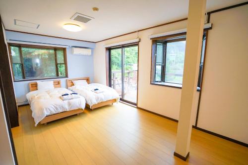 two beds in a room with two windows at Marine Blue Yakushima in Yakushima