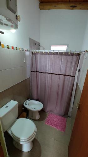 un baño con inodoro y lavabo en Cabañas Mónika IV Sur, en Huerta Grande