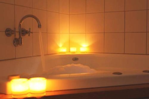 e bagno con vasca, candele e luci. di Gullyview Spa Cottage Daylesford- Walk to town a Daylesford