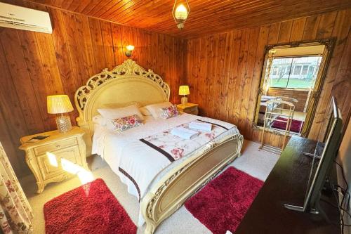 a bedroom with a large bed in a room with wooden walls at Hostal HM in Lautaro
