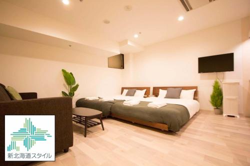 a bedroom with a bed and a flat screen tv at SEVEN Building / Vacation STAY 4950 in Asahikawa