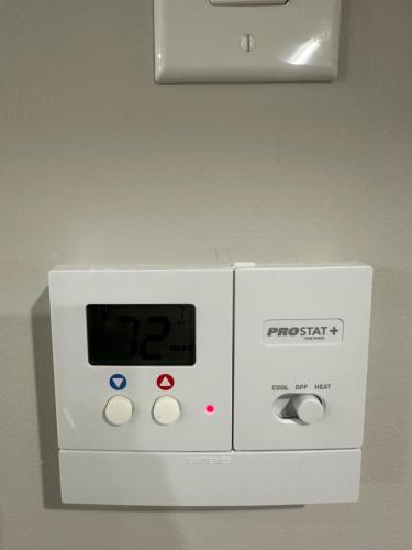 a white machine with a clock on a wall at A Luxurious Cozy Place in Calgary