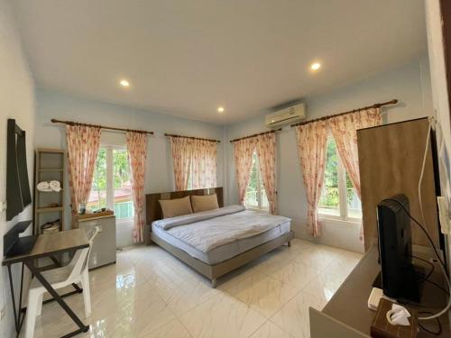 a bedroom with a bed and a tv and windows at Goldengold (Khaoyai) Resort & Spa in Mu Si