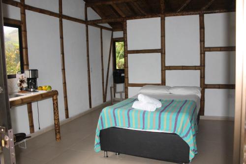 a bedroom with a bed in a room with windows at Cabaña Nido de Amazilia in Manizales