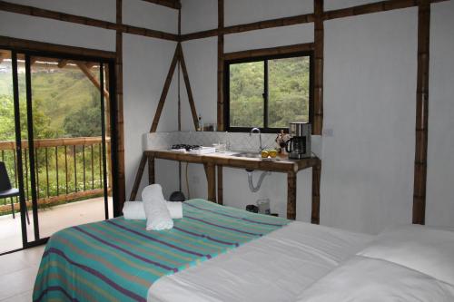 a bedroom with a bed and a sink and windows at Cabaña Nido de Amazilia in Manizales