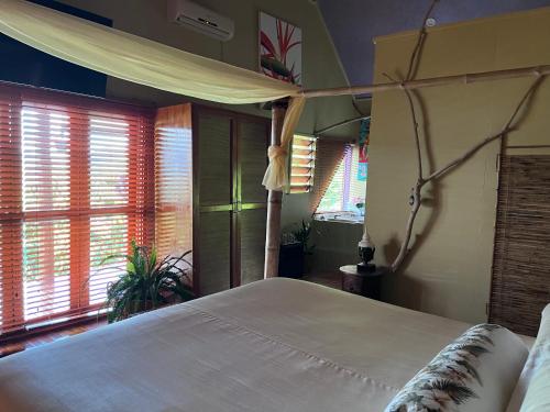a bedroom with a large white bed and windows at Naveria Heights Lodge in Savusavu