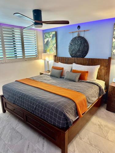 a bedroom with a large bed with an orange blanket at This place is different!! Award winning! Oceanfront, View View! in Wailuku