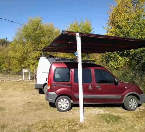 a red van with a canopy on top of it at Altos del Peñón Cabañas in Casa Grande