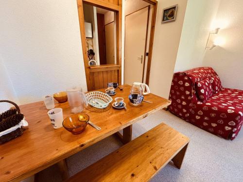 - une table en bois dans une chambre avec une chaise rouge dans l'établissement Studio pour 4 avec balcon, proche pistes, animaux admis à Vallandry - FR-1-757-119, à Landry