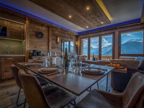 - une salle à manger avec une table, des chaises et des montagnes dans l'établissement Appartement chalet 2 chambres, centre Courchevel 1850, ski à 150m, WIFI - FR-1-631-213, à Courchevel