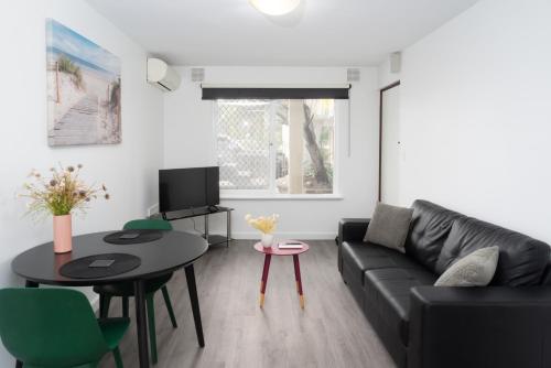 a living room with a black couch and a table at Apartment 16 Burswood in Perth