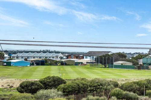 a green tennis court with houses in the background at Range View House 23 Bristow Smith Ave Goolwa South-No Linen Included in Goolwa South