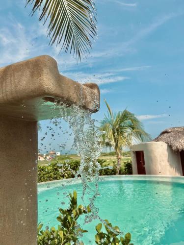 a water fountain in front of a swimming pool at El Origen Villas & Spa-Puerto Escondido in Puerto Escondido