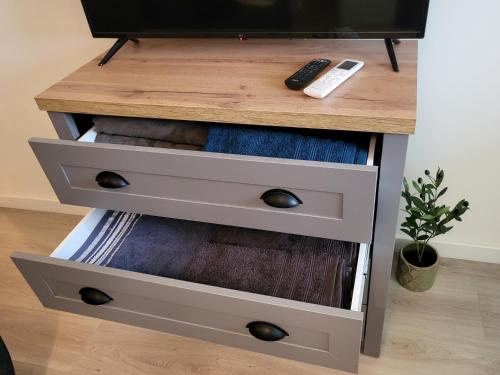 a night stand with two drawers and a remote control at Victoria Condo Otopeni- Self Check-in and Check- out in Otopeni