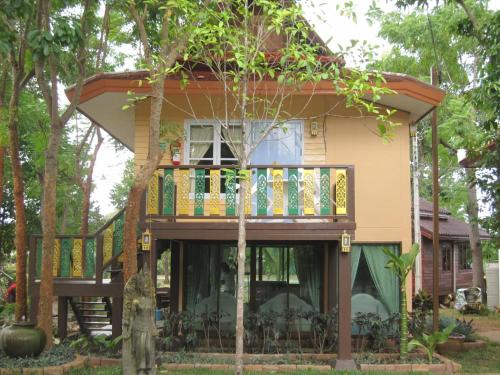 a house with a wrap around deck in the trees at Goldengold (Khaoyai) Resort & Spa in Mu Si