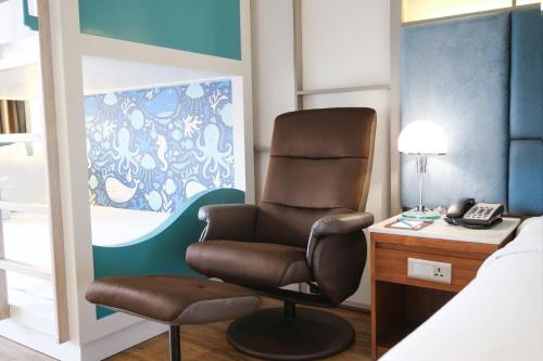 a bedroom with a chair and a desk and a bed at Seaesta Nha Trang Hotel in Nha Trang