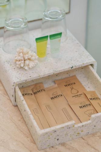 a wooden table with two glasses and a box on it at Seaesta Nha Trang Hotel in Nha Trang