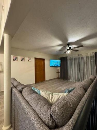 a living room with a couch and a tv at CasaNinos, casa de la gente buena in Aguascalientes