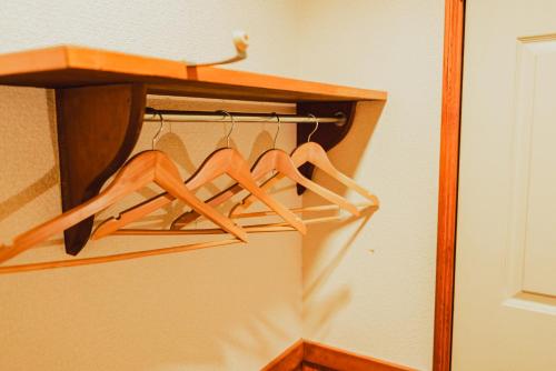 a wardrobe with wooden hangers in a room at Hakuba Pension & Log Hotel Meteor in Hakuba