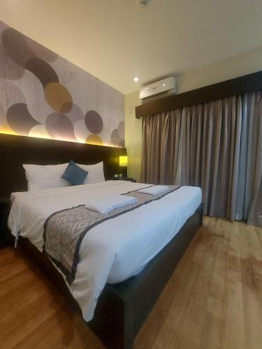 a bedroom with a large bed in a room at Whitewoods Convention and Leisure Hotel by SMS Hospitality in Silang