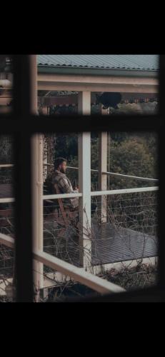 a man is looking out of a window at Jamieson Lake Home in Howqua